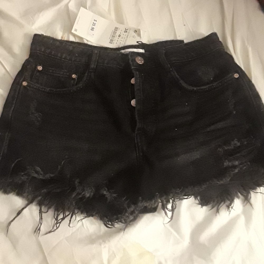 Distressed black denim cutoffs